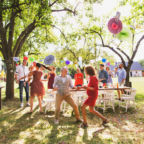 A senior couple with extended family dancing on a garden party or family celebration outside in the backyard.